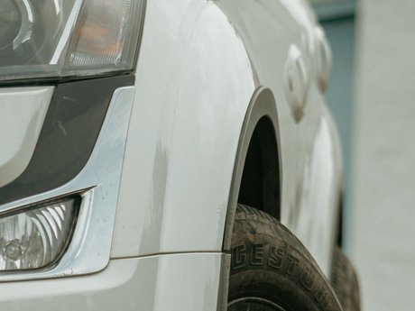 Close-up of the headlights and front wheel of a white car